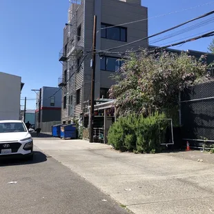 the entrance from outside on the sidewalk. it&apos;s behind a bush in a parking lot.