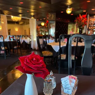 a red rose in a white vase