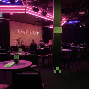 people sitting at tables in a dimly lit restaurant