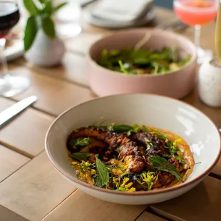 a bowl of food and a glass of wine