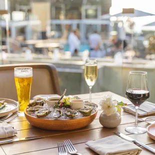 a table set for two with plates of food and glasses of wine