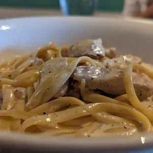 a bowl of pasta with chicken and mushrooms