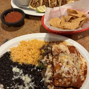 Asada sopapilla with black beans and rice, chips and salsa, and tacos al pastor with refried beans.
