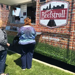 two women standing in front of a food truck