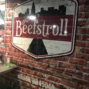 a man standing in front of a brick wall