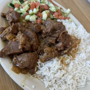 a plate of rice, meat and vegetables