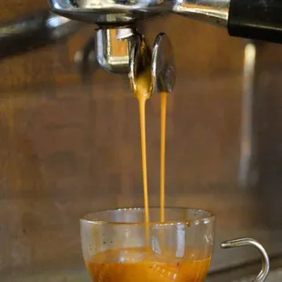 a coffee being poured into a cup