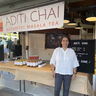 a woman standing in front of a table of tea