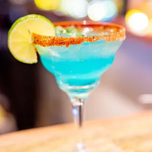 a blue margarita with a lime wedge