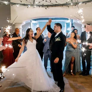 Capture the magic as the bride and groom exit under a stunning gazebo, surrounded by sparkling lights and joyful guests with sparklers!