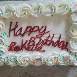 a birthday cake with white frosting and colorful sprinkles