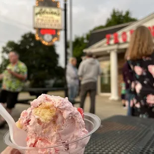 a hand holding a bowl of ice cream