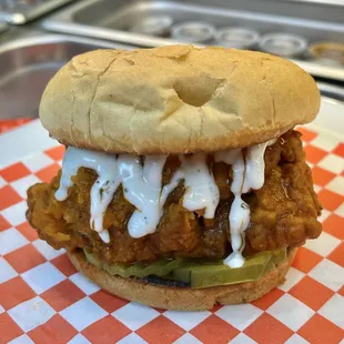 Buffalo chicken sandwich with ranch, spicy sweet Sriracha, pickle and buffalo sauce.