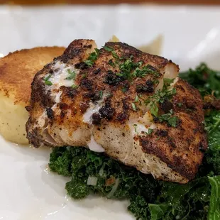 a piece of fish on a bed of kale