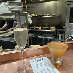 a glass of champagne and a menu on a counter