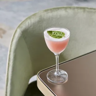 a pink drink in a glass on a table