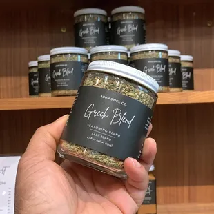 a hand holding a jar of spice