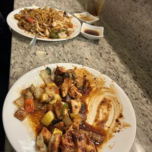 The 1st plate is the spicy chicken,  it was bomb. I couldn&apos;t wait to eat so excuse the picture lol then the far plate was steak yakisoba.