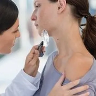 Advanced Dermatology &amp; Skin Cancer Specialists - doc examining mole on woman neck