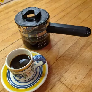 a coffee pot and a cup of coffee