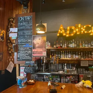 a wooden bar with a chalkboard menu
