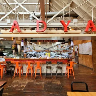 the inside of a restaurant with orange chairs
