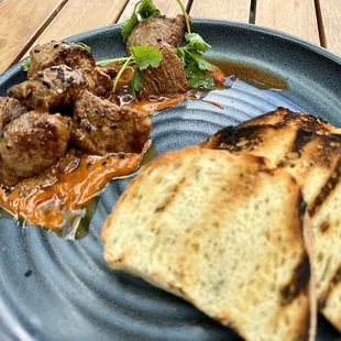 Steak bites with anticucho sauce, cilantro, sesame, and grilled toast