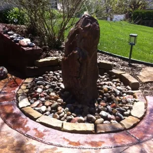 a stone fountain in a garden