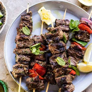 a plate of kebabs and a bowl of salad