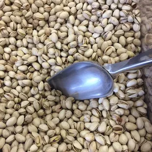 a scoop in a pile of pistachios