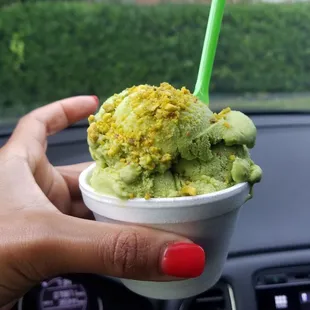 a person holding a cup of ice cream