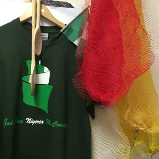 a green t - shirt and a red mesh bag