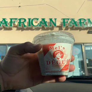 a hand holding a cup of ice cream