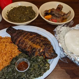Grilled tilapia, Jollof rice, and greens (on plate), cassava Leaves, salted fish, &amp; fufu