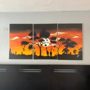 a painting of giraffes at sunset