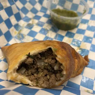 Inside of beef sambusa with green salsa hot sauce