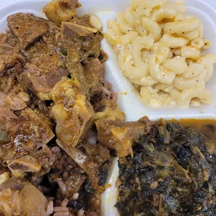 Curry goat with Mac and cheese and spinach