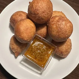 a plate of bread rolls with dipping sauce