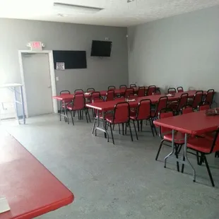 a large room with red tables and chairs