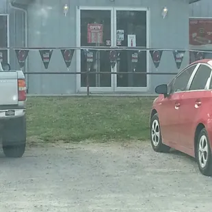a red car parked in front of a restaurant