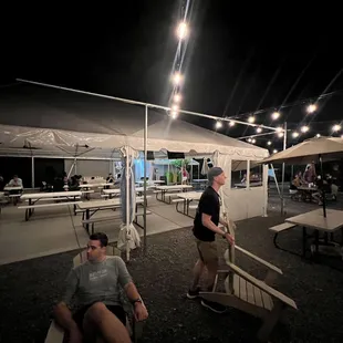 a man and a woman sitting under a tent