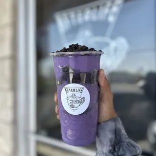 a hand holding a cup of boba