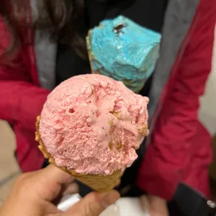 a person holding a cone of ice cream