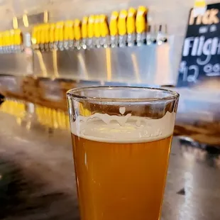 a glass of beer on a bar