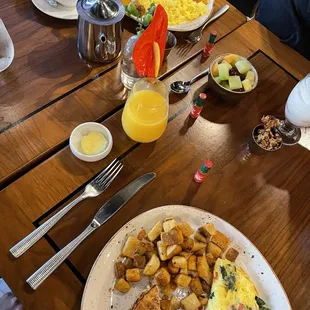 a breakfast of eggs, toast, potatoes, and fruit