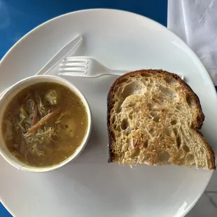 a bowl of soup and a sandwich on a plate