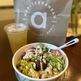 a bowl of salad and a drink