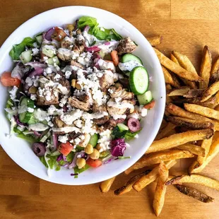 a bowl of salad and french fries