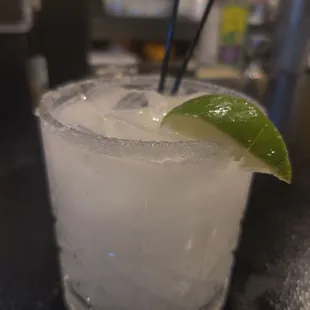 a closeup of a margarita with a lime wedge
