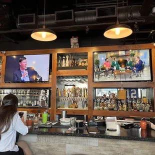 a bar with people watching tvs